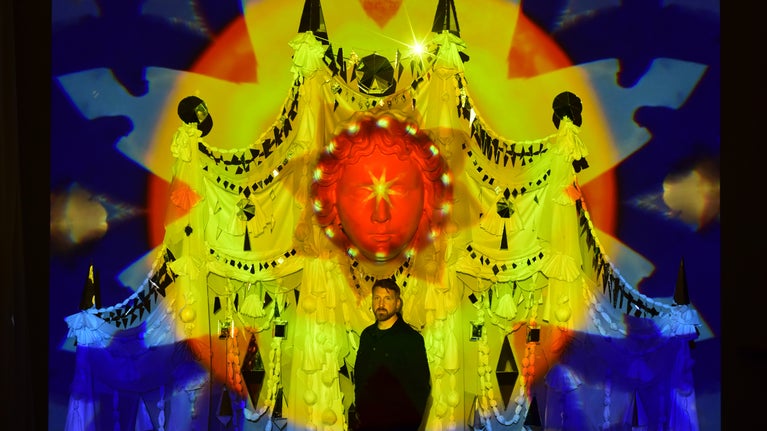 Artist, Ed Kluz stand in front of his installation Between Chaos and Light at Fountains Hall